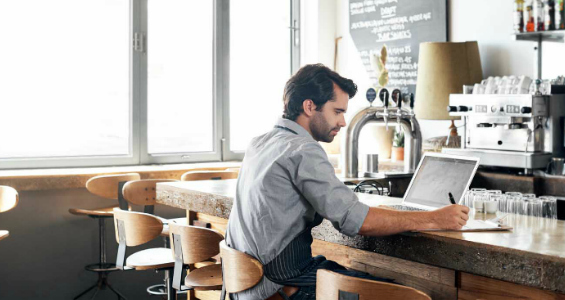 Business owner sitting at counter with laptop