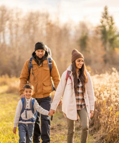 A couple walking with their son in the fall