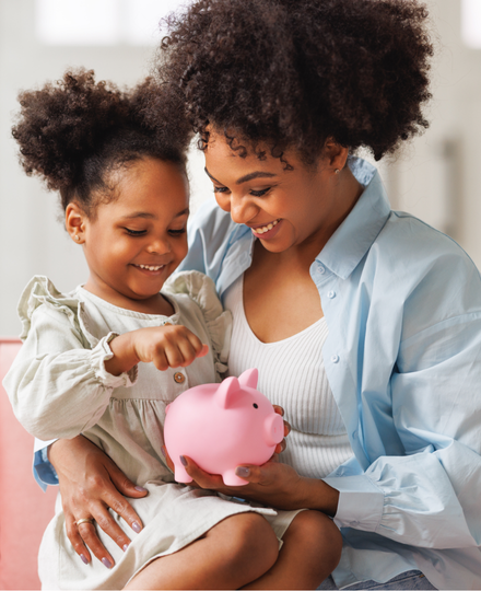 Mom and daughter putting a coin into a piggy bank