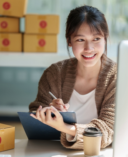 Asian business woman owner looking at laptop