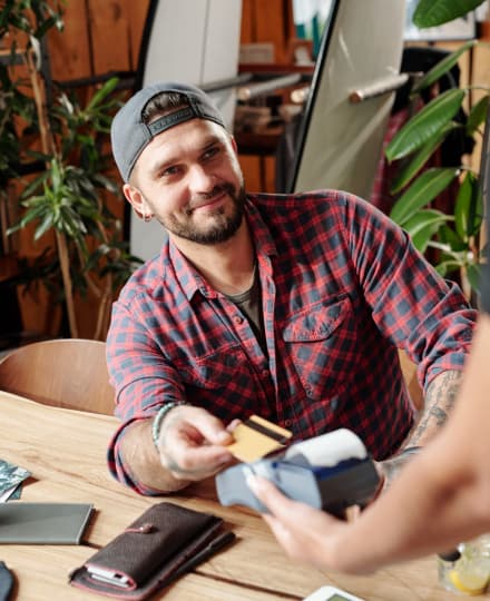 a white man in his late twenties paying for dinner. 