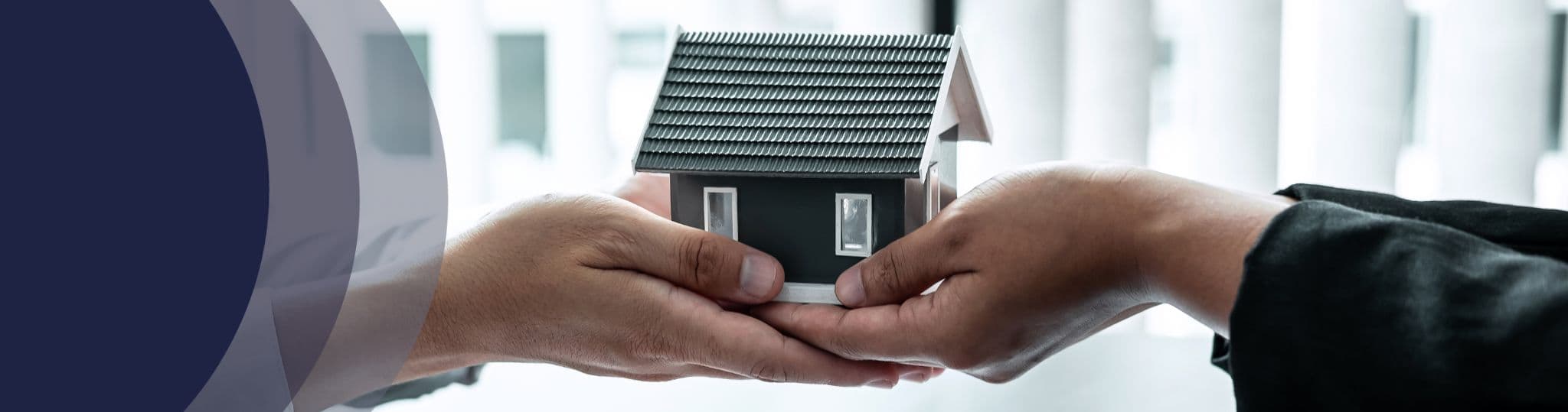 two people holding a small house
