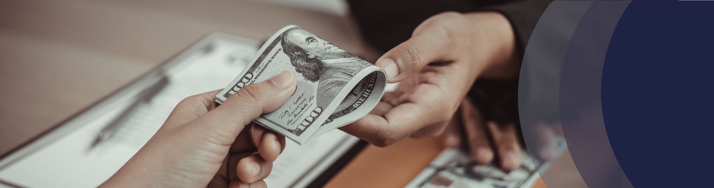 hands exchaning a hundred dollar bill