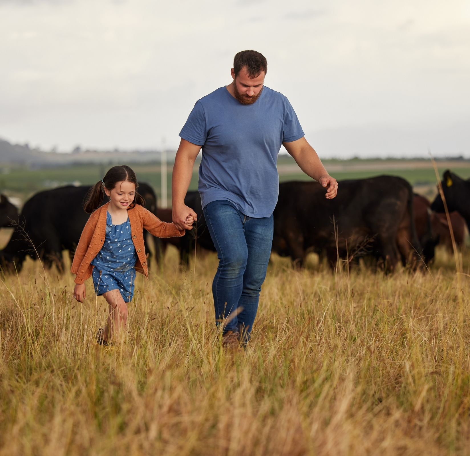 father and daughter walking through a field
