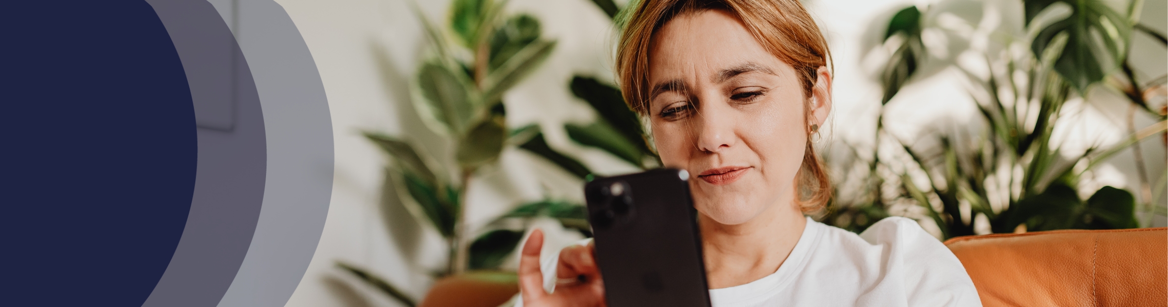 woman looking at cell phone on her couch