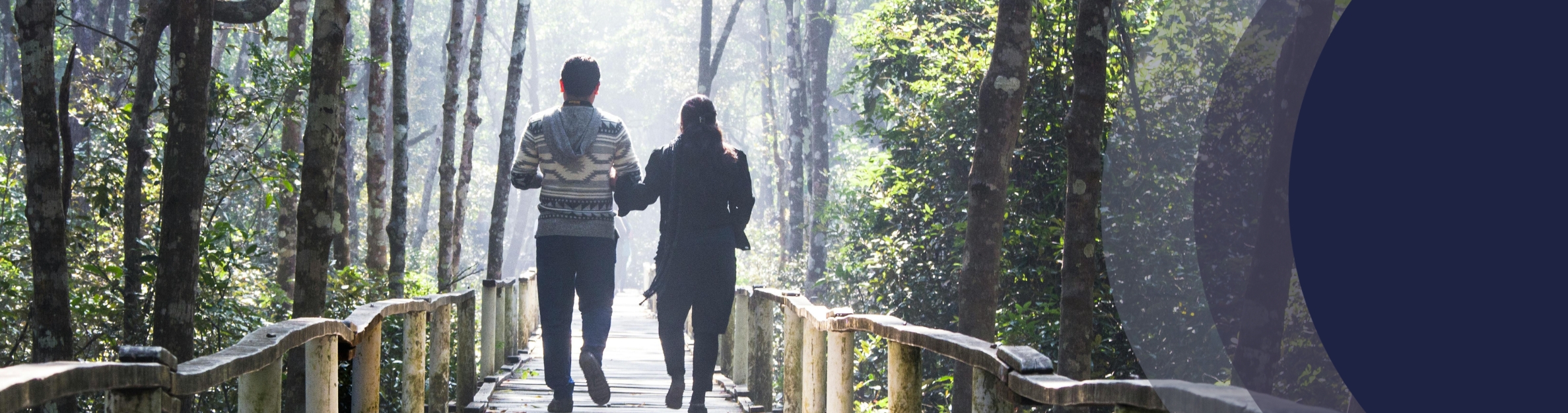 A male and female walking across a bridge
